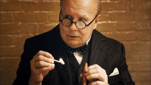 Gary Oldman as Winston Churchill, lighting a cigar