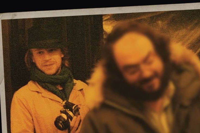 Leon Vitali, standing in the background with Stanley Kubrick out of focus in the foreground.